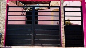 A gated entrance with a stone facade and a metal gate.