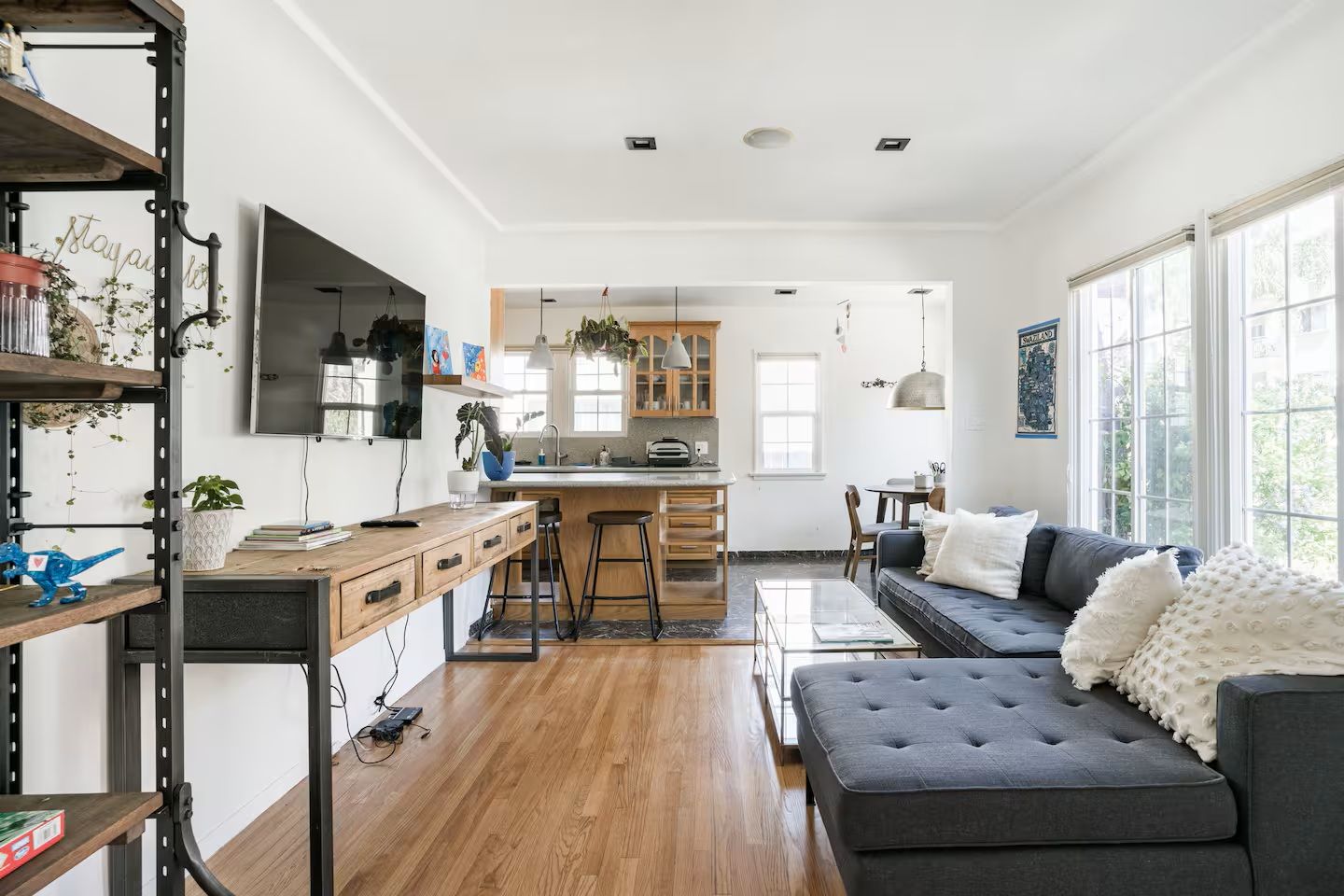 A modern kitchen with wooden cabinets, a central island, and pendant lighting.