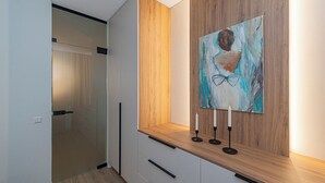 Un interior modern amb una paret d'accent de fusta, un quadre i un farol.