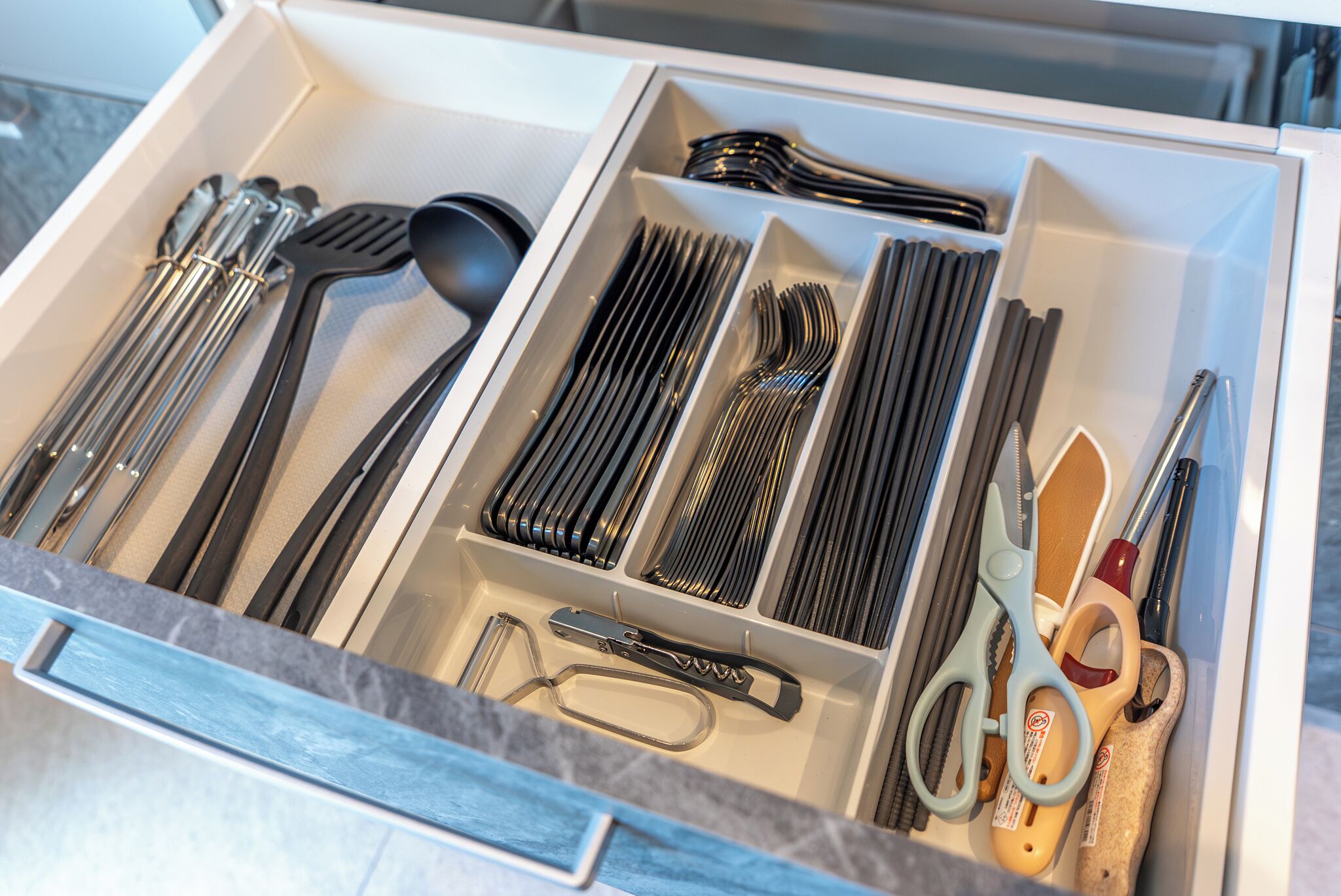 Un cajón con diversos utensilios y herramientas de cocina.