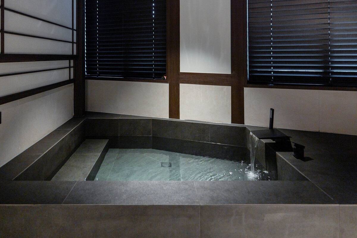 Un baño tradicional japonés con estructura de madera y puertas correderas.