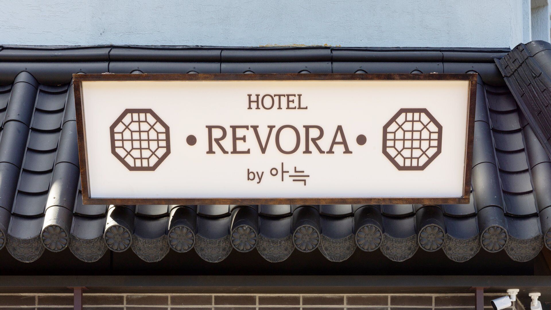 Segnaletica di un hotel con il nome 'REVORA' e un logo.