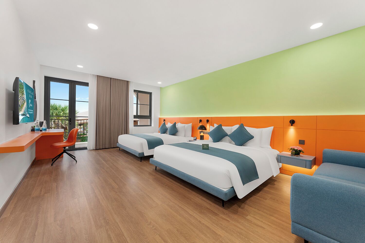 A hotel room with two beds, a desk, a chair, and a balcony with a view.