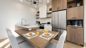 A modern kitchen with a central island, stainless steel appliances, and wooden cabinetry. - Panorama 1249: Majestic River View, Spacious Patio (Petite-Rivière-Saint-François)