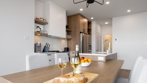 A modern kitchen with wooden cabinets, a built-in oven, and a stainless steel refrigerator. - Panorama 1251: Private & Luxury, River Sunsets (Petite-Rivière-Saint-François)