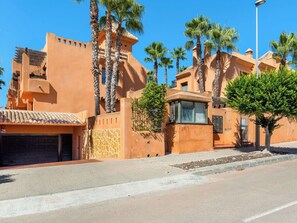 Ein Gebäude mit Garage, Palmen und blauem Himmel.