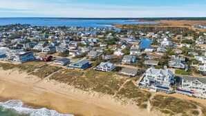 An aerial view of a coastal residential area with houses, a beach, and a body of water. - Anthem of the Sun | Oceanfront | Private Pool and Hot Tub (Virginia Beach)