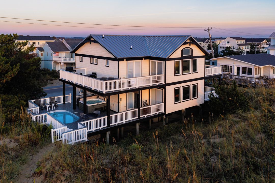 Une maison à deux étages avec un balcon et une piscine.