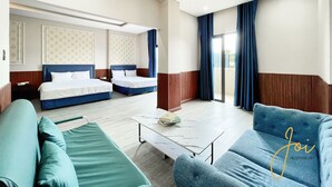 A hotel room with two beds, a sofa, a coffee table, and a sliding glass door leading to a balcony. - Phuong Hoang Hotel  (Ho Chi Minh City)