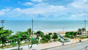 A coastal view with a beach, palm trees, and a sign for 'Elvis Star Poseido' hotel. - Phuong Hoang Hotel  (Ho Chi Minh City)