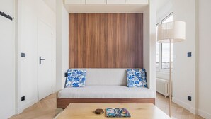 Een moderne woonkamer met een bank, een salontafel en een houten accentmuur.