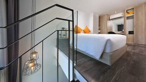 A modern hotel room with a bed, a desk, and a wardrobe. - Utopia Loft Aparthotel by Sabai Sands (Rawai)