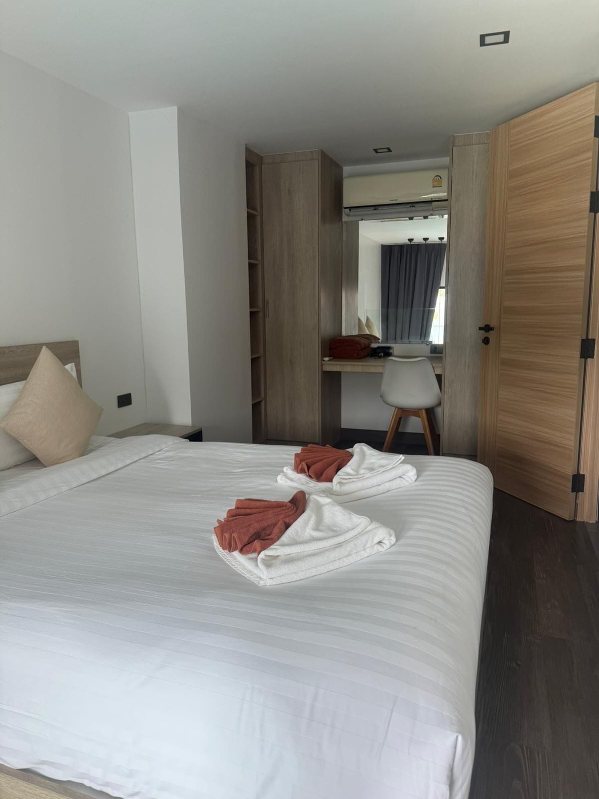 Una habitación de hotel con una cama, un escritorio y un armario.