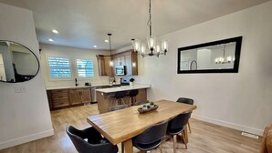 Una cucina moderna con mobili in legno, un'isola centrale e un'area pranzo con tavolo e sedie di legno.