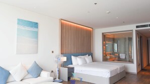 A modern hotel room with a bed, a sofa, a small table, and a large window. - OceanView Hạ Long • Large Balcony • TwinBed (Thành phố Hạ Long)