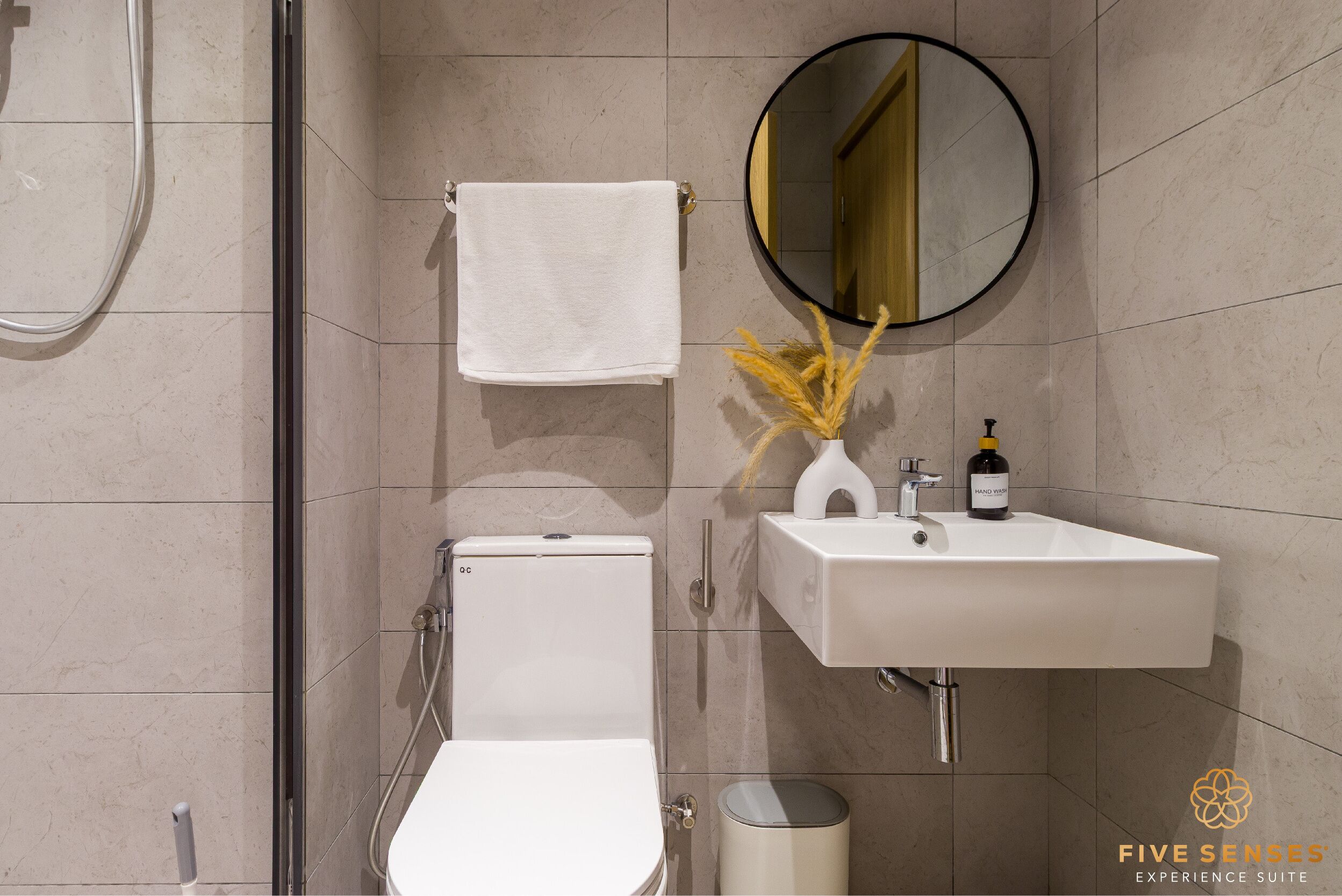 Een moderne badkamer met toilet, wastafel en spiegel.