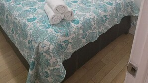 Une chambre à coucher avec un lit, un oreiller et une serviette enroulée.