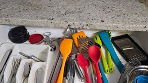 Een keukulaag met diverse keukengerei en -hulpmiddelen.