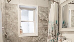 A bathroom with a bathtub, a window, a toilet, and a sink. - Lovely App Downtown Ottawa 211D (Ottawa)