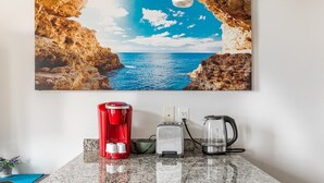 Een aanrecht met een koffiezetapparaat, broodrooster en waterkoker.