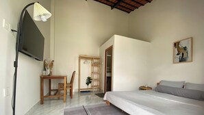 Ein Schlafzimmer mit Bett, Schreibtisch, Stuhl, Lampe und Kleiderschrank.