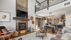 A spacious living room with a fireplace, a dining area, and a kitchen. - MK Hideaway Mountain Cabin w/ Hot Tub (Lead)