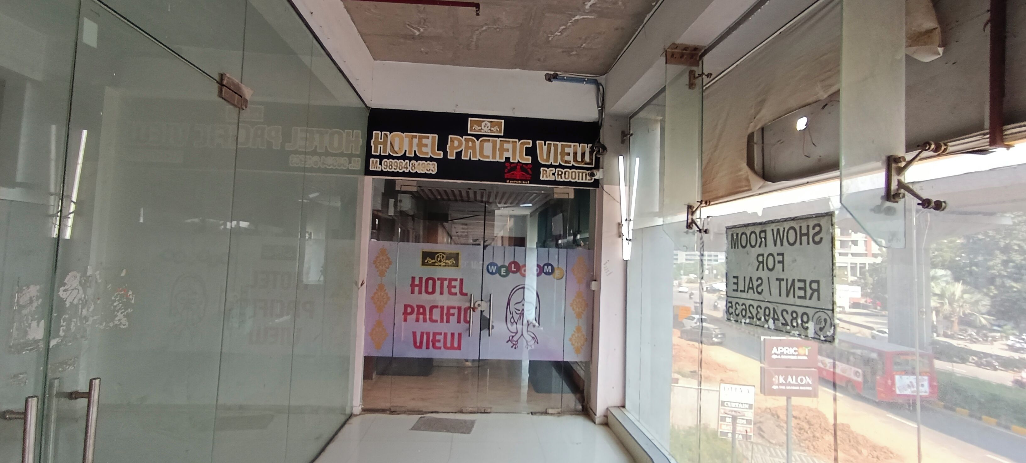 Entrada de un hotel con un cartel que indica 'Hotel Pacific View' y 'Habitaciones AC'.