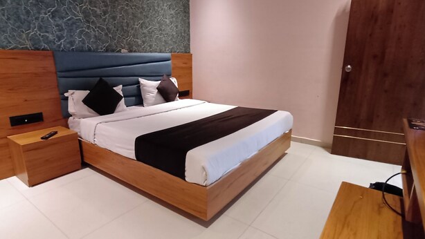 Un dormitorio moderno con estructura de cama de madera, una mesita de noche y un escritorio de madera.