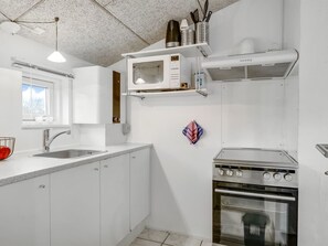 Een koelkast, kookgerei, borden en bestek