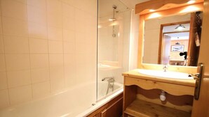A bathroom with a glass shower enclosure, a wooden vanity with a sink, and a mirror. - Dbac23 - 3 Bedroom Apartment - Balcony - Sleeps 8 - 1800 Area (Puy-Saint-Vincent)