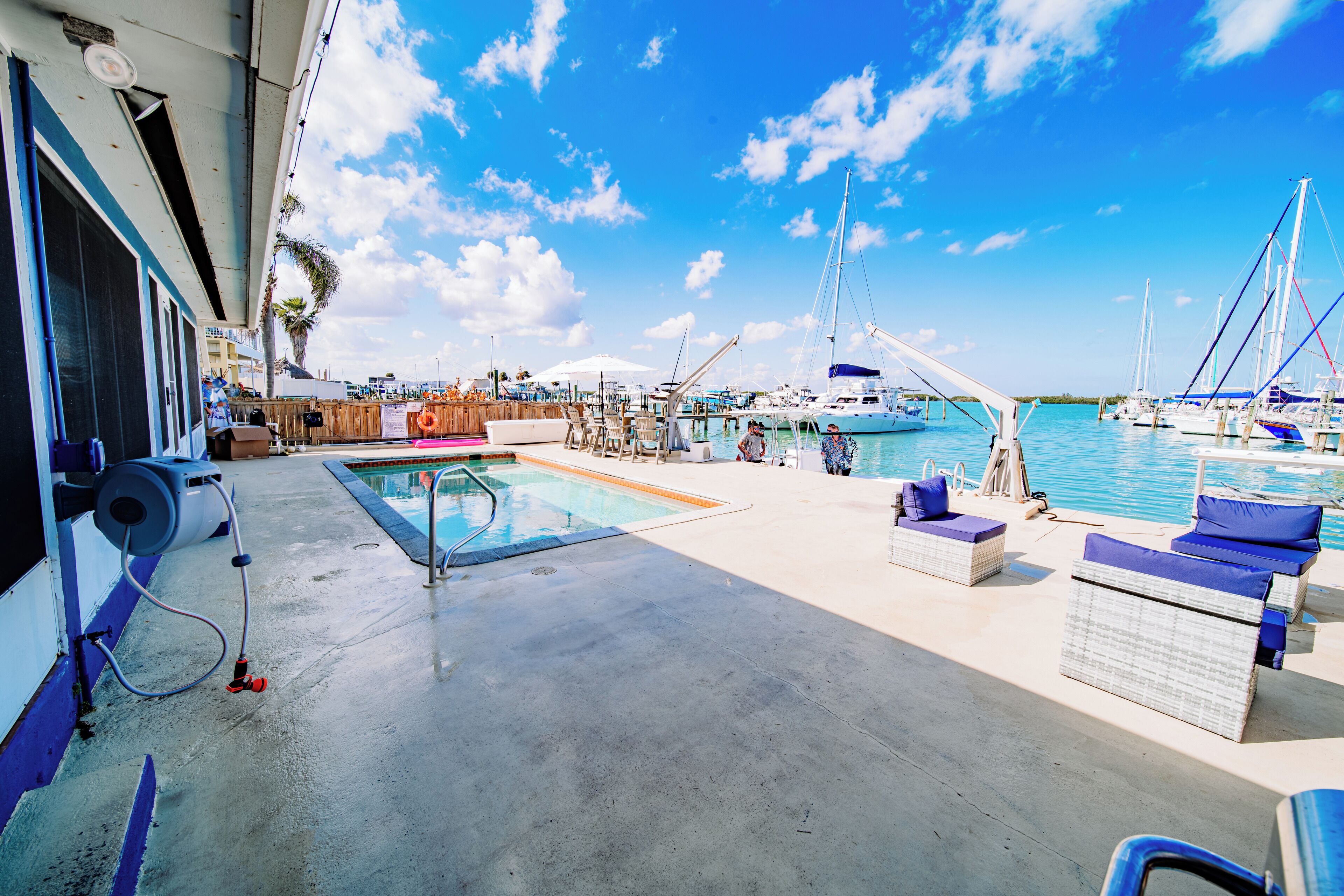 A marina with boats, a swimming pool, and outdoor seating.