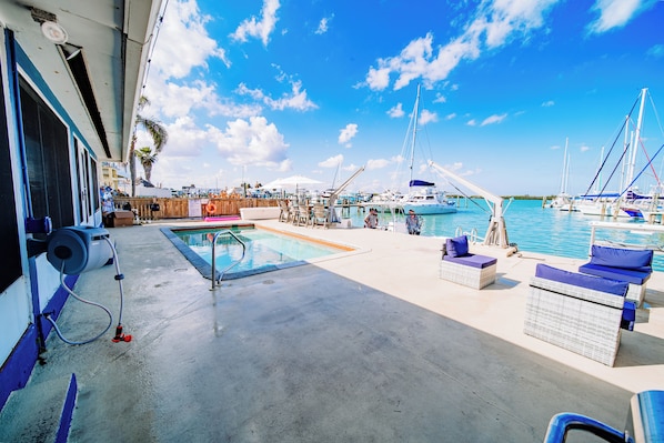 A marina with boats, a swimming pool, and outdoor seating. - Waterfront Pool House on Hutchinson Island (Fort Pierce)