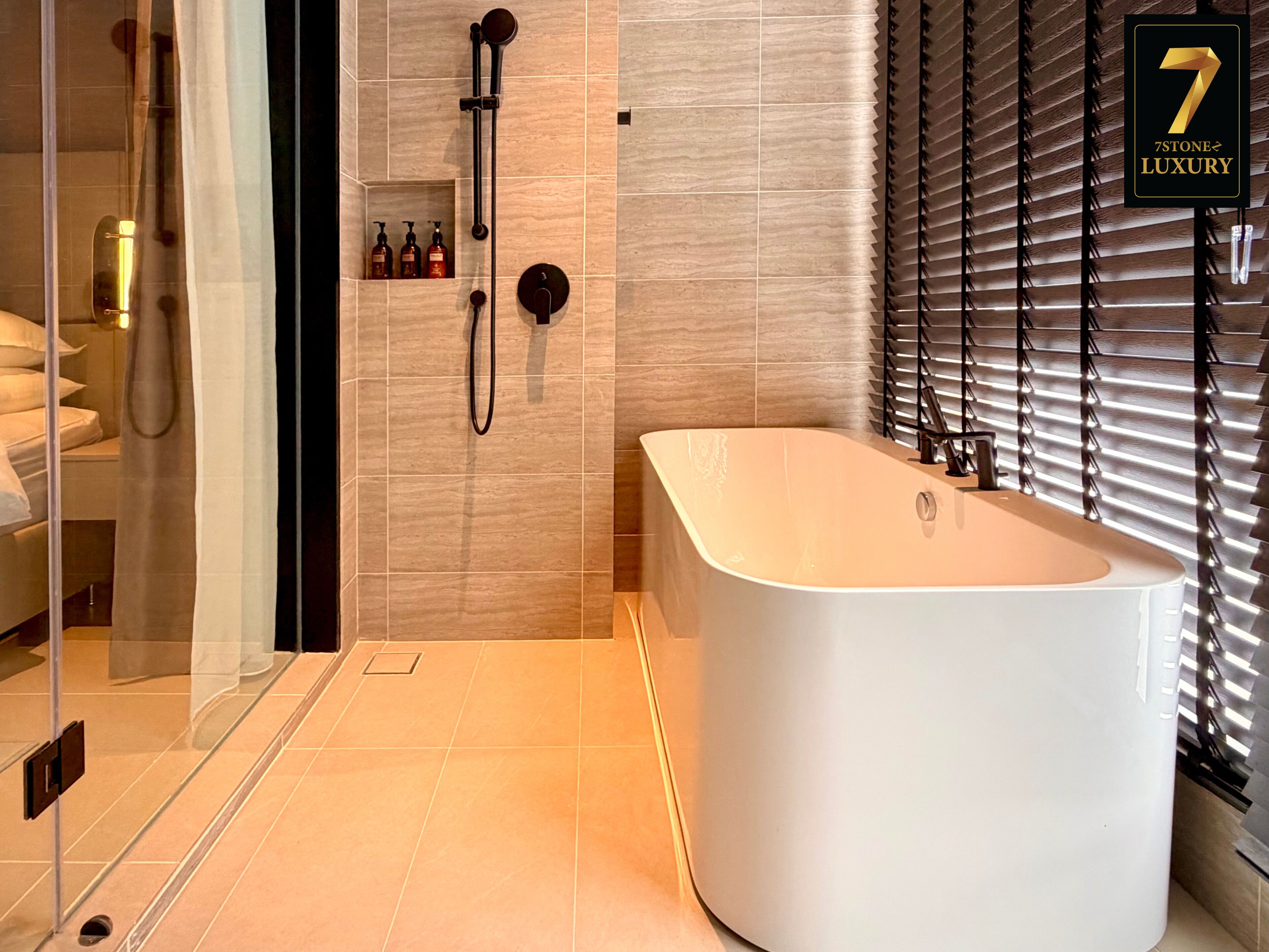 A modern bathroom with a freestanding bathtub, a glass shower enclosure, and a vanity with toiletries.