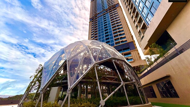 Un bâtiment moderne doté d’une façade en verre et d’une structure métallique originale à l’avant.