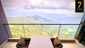 Un balcon doté d’une table et de chaises, offrant une vue sur un paysage montagneux.