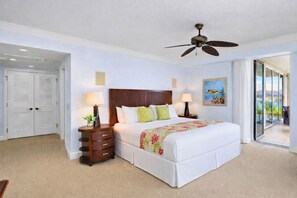 A hotel room with a bed, two bedside tables, a ceiling fan, a painting, and a sliding glass door leading to a balcony. - 2 Honua Kai Villas | Ocean Front | Sleeps 12 | Free Car w/ 6+ Nights | ML-1820 (Lahaina)