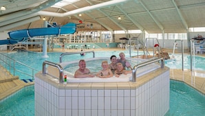 Ein Hallenbad mit Whirlpool, Liegestühlen und einem Café.