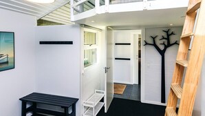 Una habitación moderna, de varios niveles, con una litera, un escritorio y una escalera.