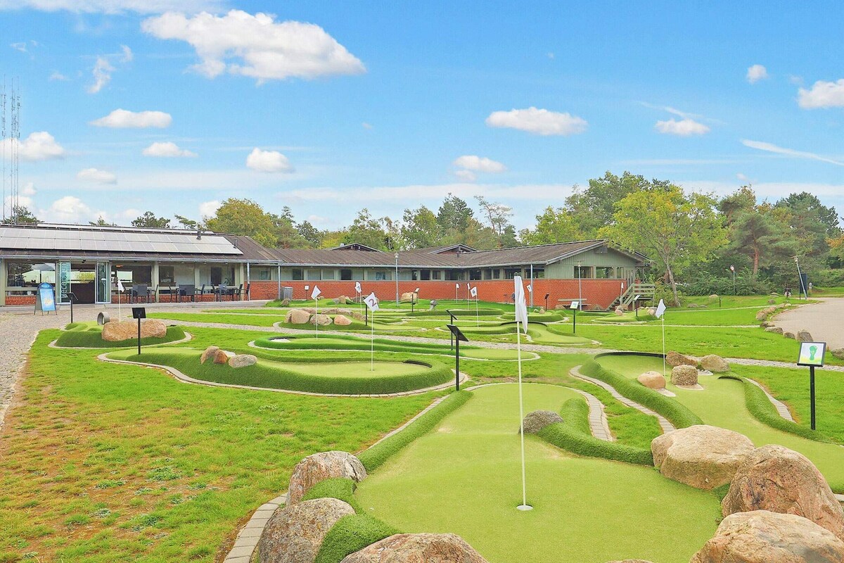 A miniature golf course with a building in the background.