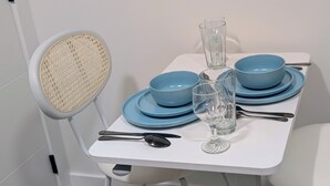 Una mesa de comedor con platos azules, una copa y cubiertos.