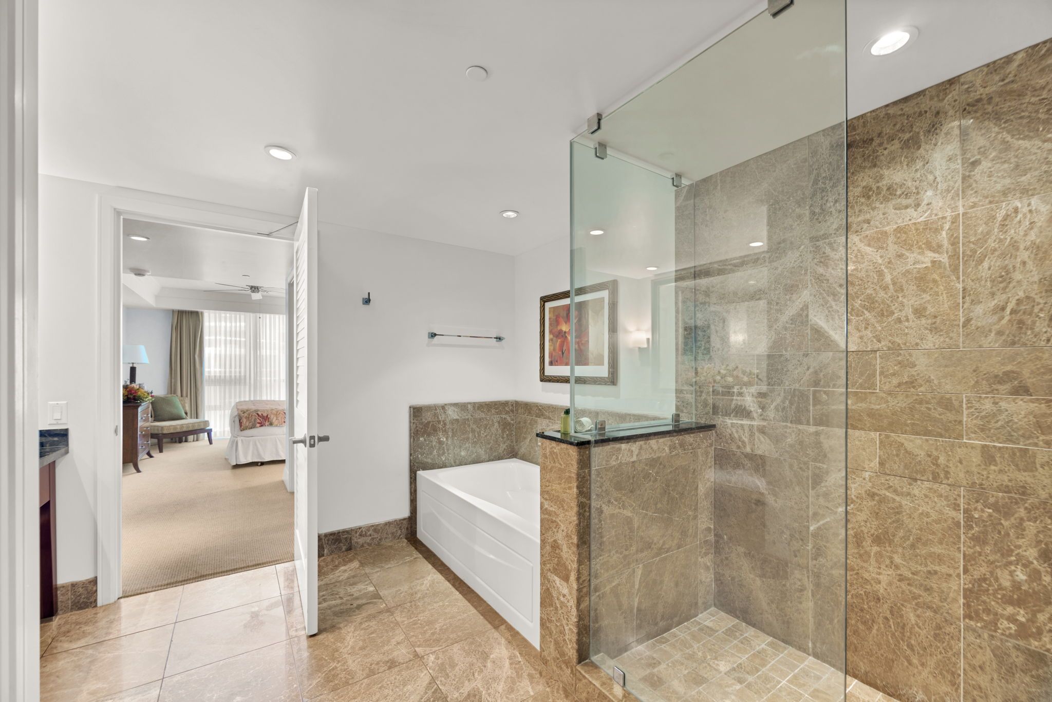 Une salle de bain moderne avec une baignoire, une douche à parois de verre et un revêtement de sol en marbre.