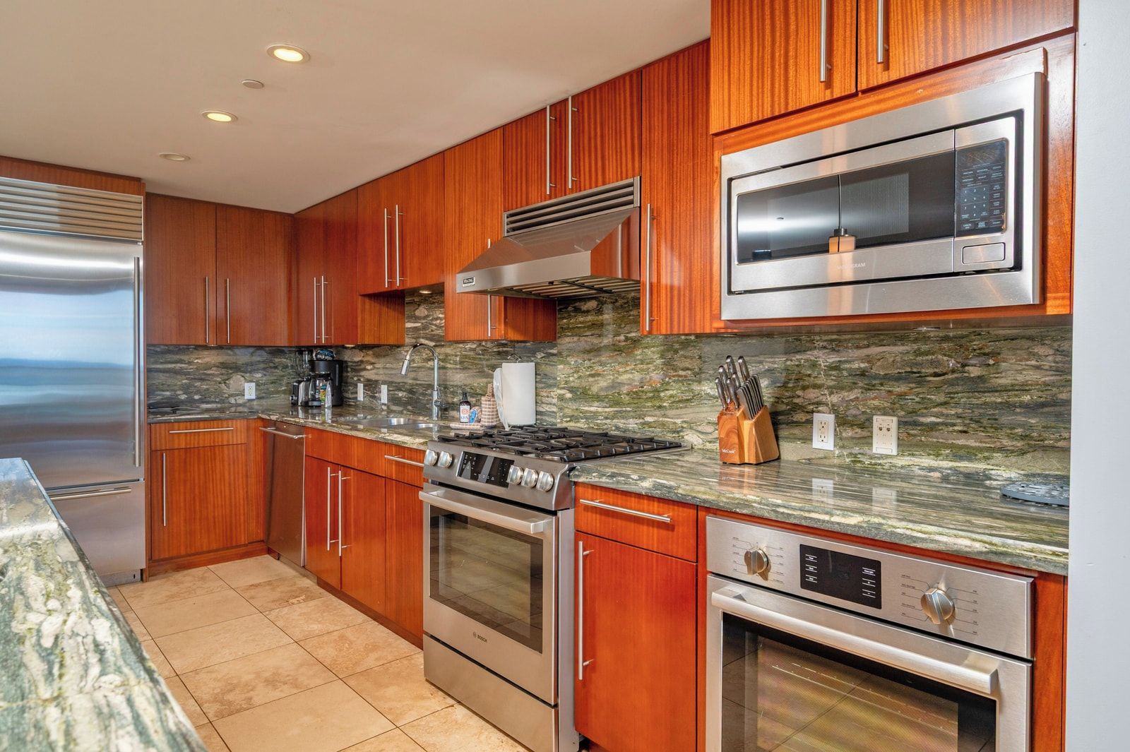 Una cocina moderna con armarios de madera, electrodomésticos de acero inoxidable y encimera de granito.
