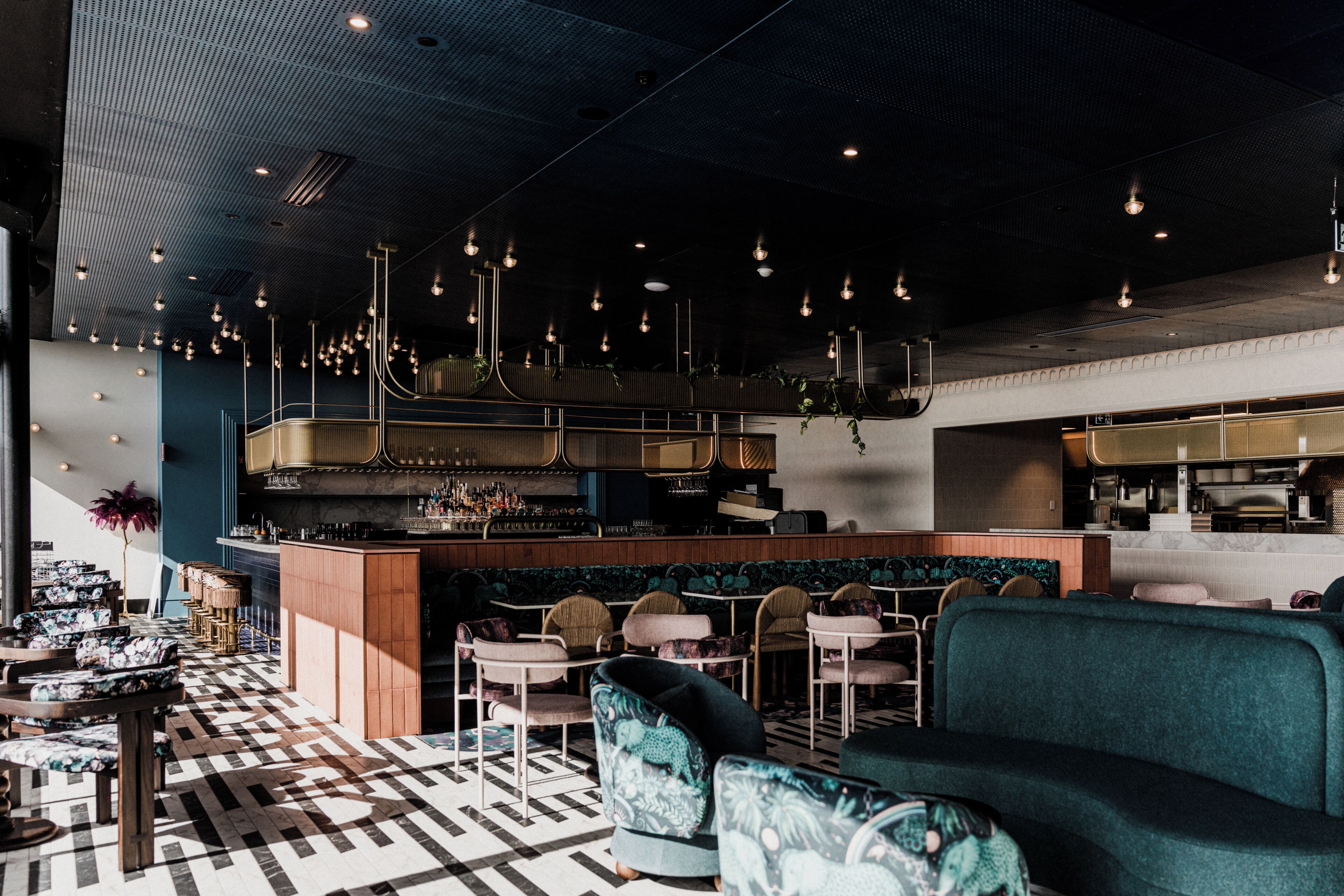 A bar area with seating, a bar counter, and hanging lights.