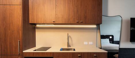 A modern kitchen with wooden cabinets, a stainless steel sink, and a built-in microwave.