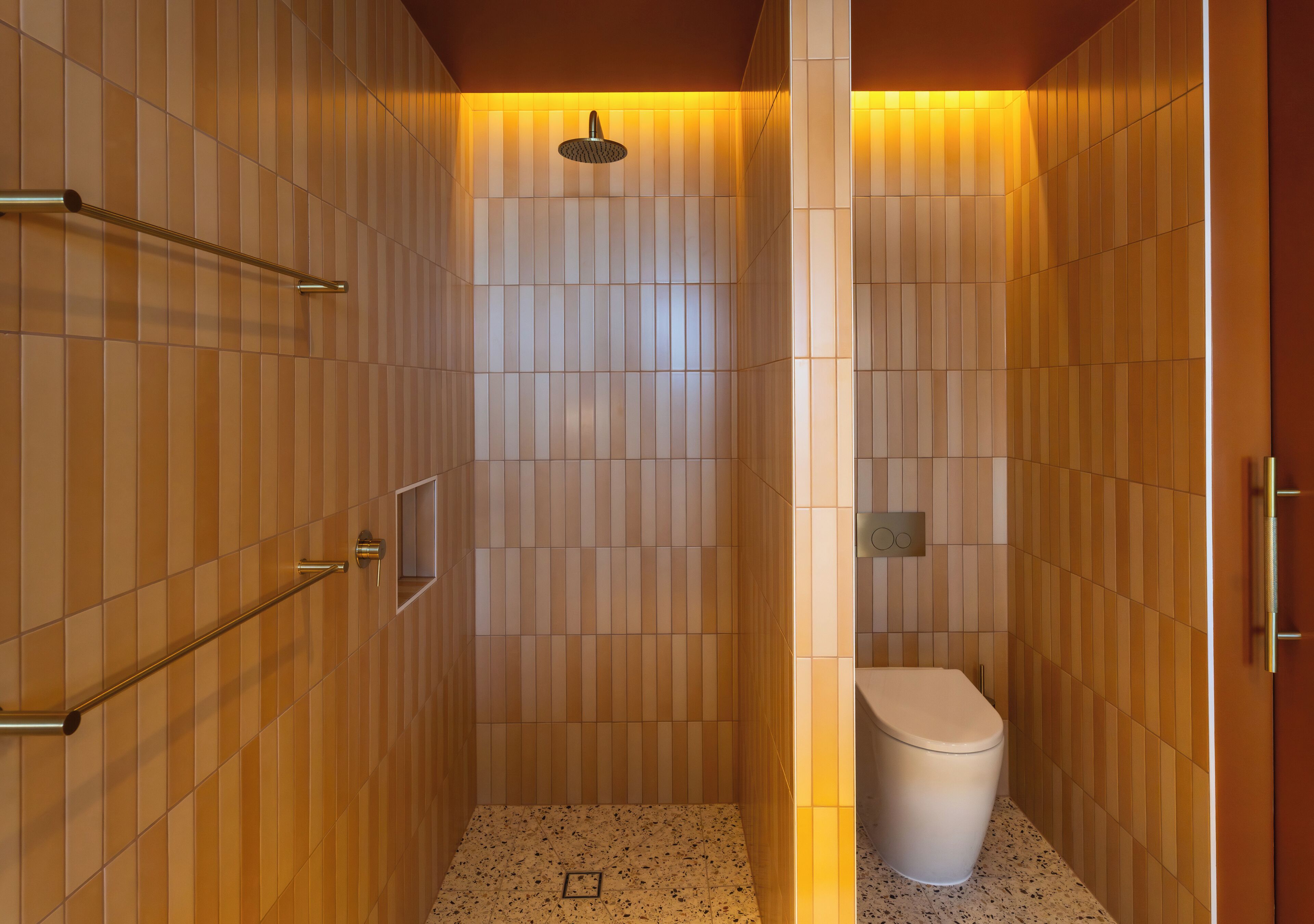 A modern bathroom with a shower, toilet, and towel rack.