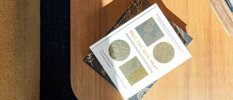 A book titled 'Salt, Fat, Acid, Heat' on a wooden table.