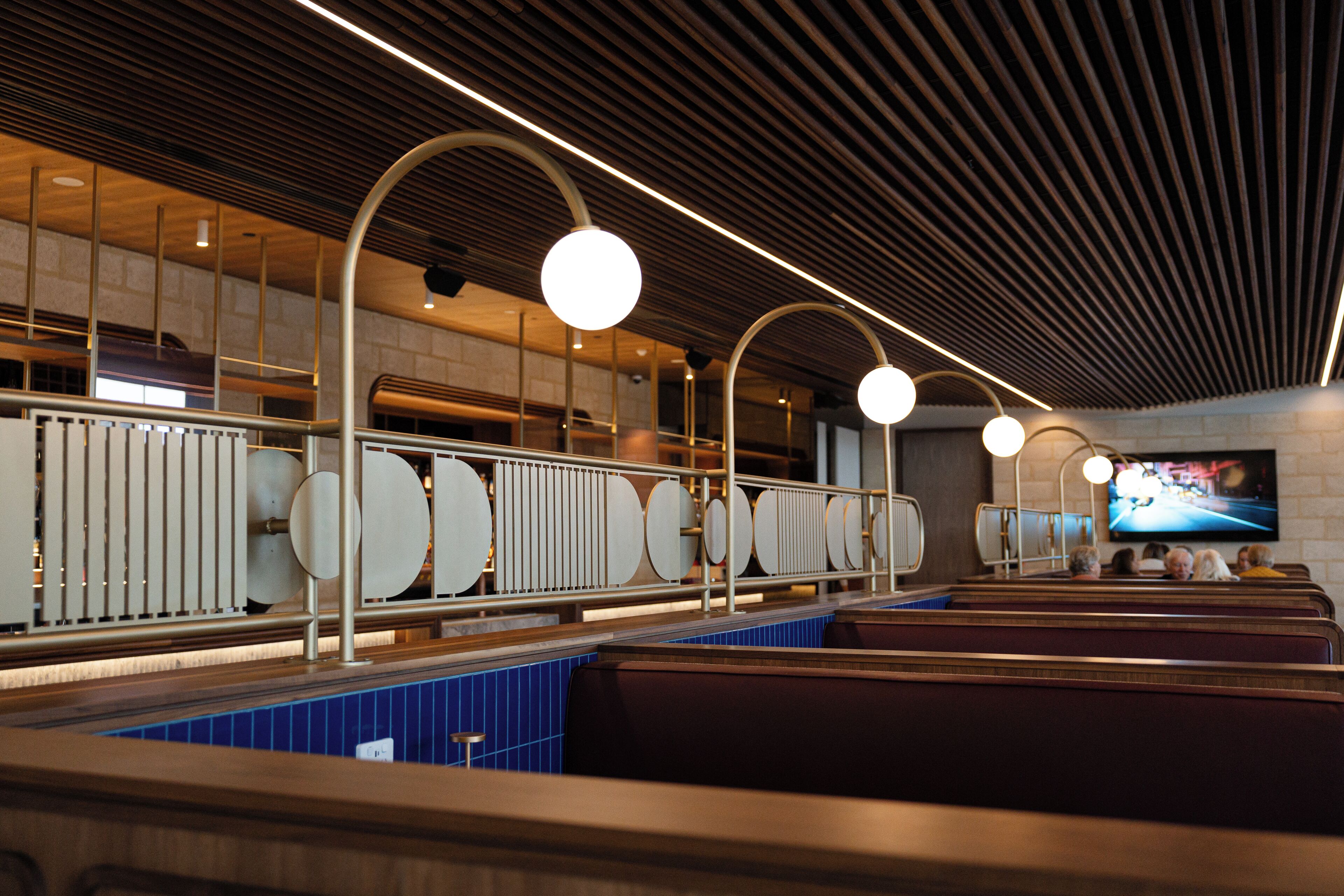 Een modern interieur met een lange toonbank, zithoek en een televisiescherm.