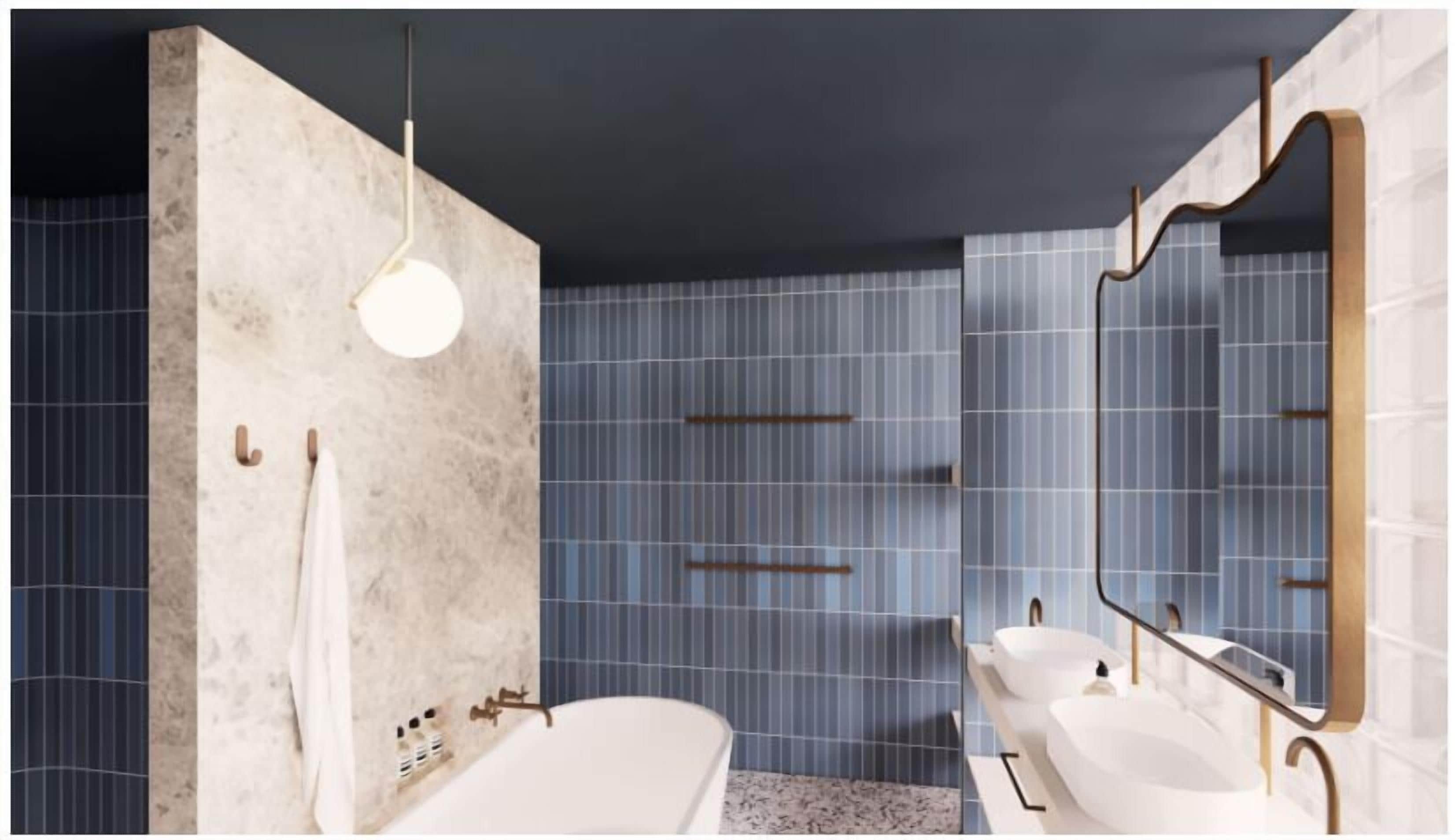 Un baño moderno con una bañera, dos lavamanos, un espejo grande y un perchero para toallas.