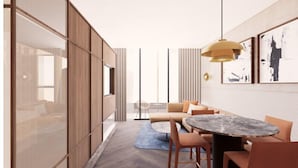 Un intérieur moderne avec un canapé, une table à manger et un luminaire suspendu.