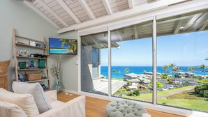 A spacious living room with a large sliding glass door leading to a balcony with a view of the ocean and resort buildings. - Kapalua Bay | Ocean View 3 BR, Sleeps 10 | Car Incl. w/ 6+ Nights | KBV ML-1963 by KBM (Lahaina)